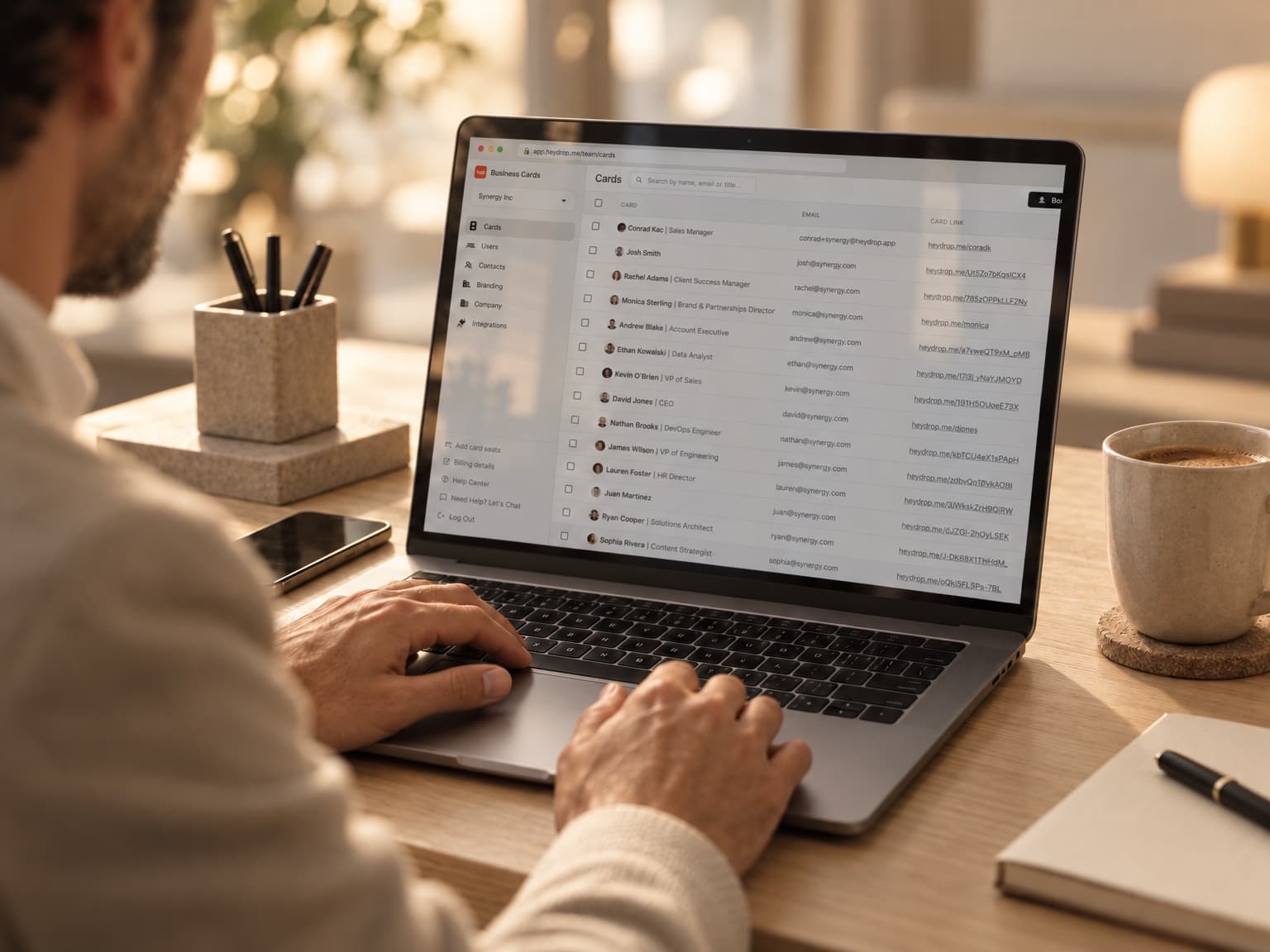 The HeyDrop Teams admin panel on a laptop, listing employee cards
